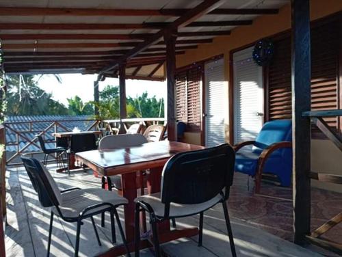 um deque com cadeiras e uma mesa e cadeiras de madeira em Hospedaje Mar Adentro em Puerto Limón