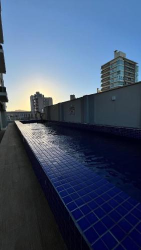 a swimming pool on the side of a building at Loft Completo Com Piscina, no centro in Tubarão