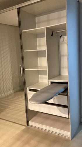 a closet with a glass door with a bed in it at Loft Completo Com Piscina, no centro in Tubarão