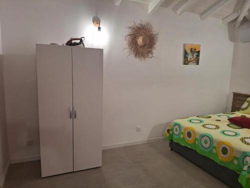 Maison cosy à Sainte-Anne - 31 m² avec terrasse في Douville: غرفة نوم مع خزانة بيضاء بجوار سرير