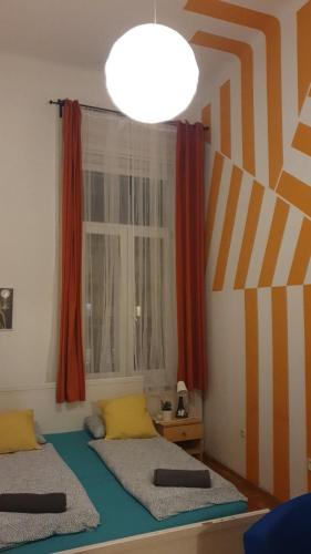 Un dormitorio con dos camas y una gran ventana. en Cozy rooms near the New York cafe, en Budapest
