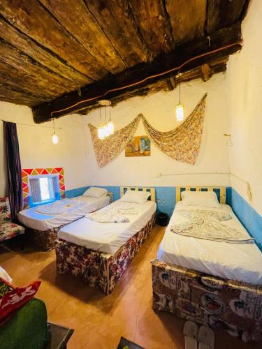 a room with two beds and a tv in it at Siwa Bait Ward Home in Siwa