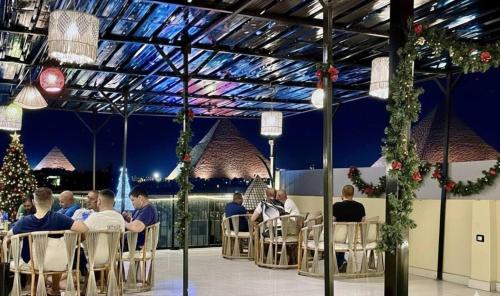 a group of people sitting at a table in a restaurant at Bedouin Camp pyramids view INN in Cairo