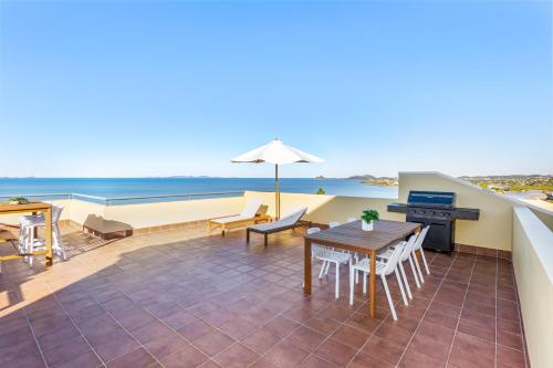 a patio with a table and chairs and the ocean at 'Villa Mar Colina U12' Coastal Escape, Yeppoon in Yeppoon