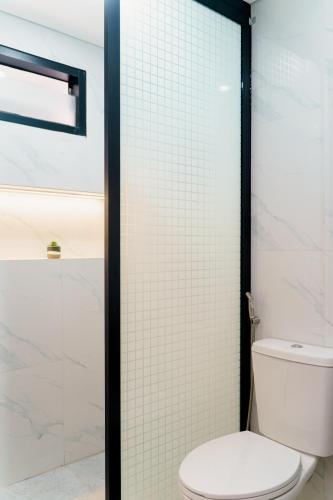 a bathroom with a toilet and a glass shower door at Griya Saka Magelang in Magelang
