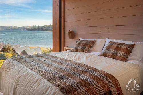 un letto in una camera con una grande finestra di Casas Arco Jardin a Castro