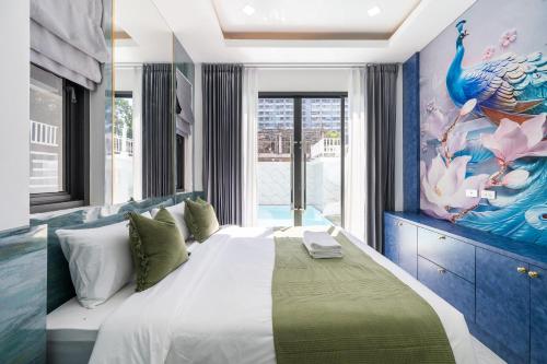a bedroom with a large bed with a peacock painting on the wall at Sorrento Pool Villa Jomtien Beach in Jomtien Beach