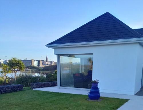a view of a house with a large window at Ferry Lodge Cottage in Kilrush