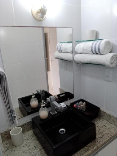 a bathroom with a black sink and a mirror at Apartamento no centro do Rio Vermelho-Ondina in Salvador