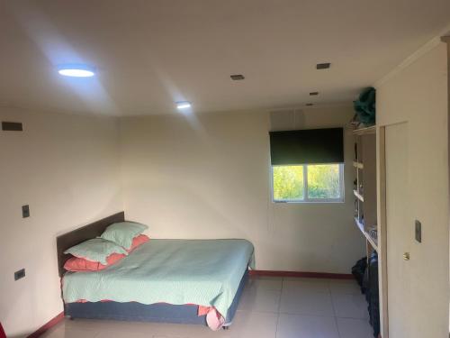 Un dormitorio pequeño con una cama y una ventana. en Departamento francisca, en Tey
