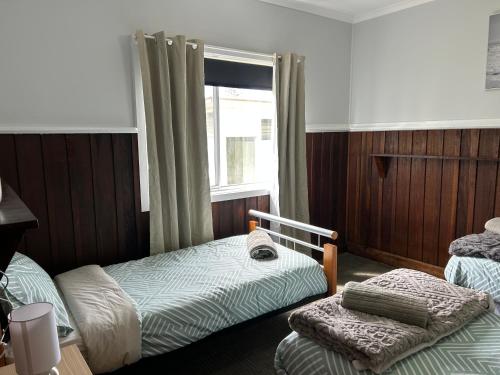 a bedroom with two twin beds and a window at Bemm River Bungalows - Bellbird Abode - Bungalow 1 in Bemm River
