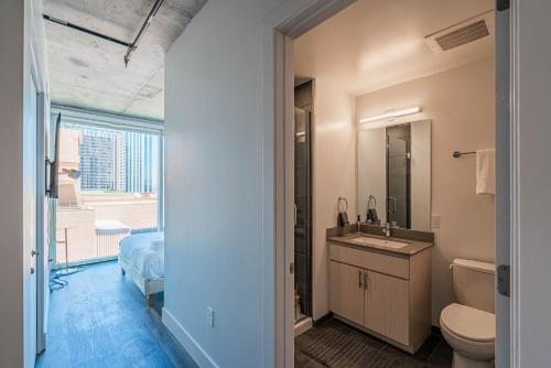 a bathroom with a sink and a toilet and a window at Panoramic Studio-1BR-3BR, Pool, Gym, Parking, Patio, BBQ in Phoenix