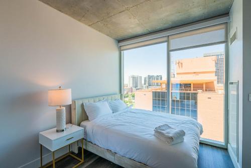 a bedroom with a bed and a large window at Panoramic Studio-1BR-3BR, Pool, Gym, Parking, Patio, BBQ in Phoenix