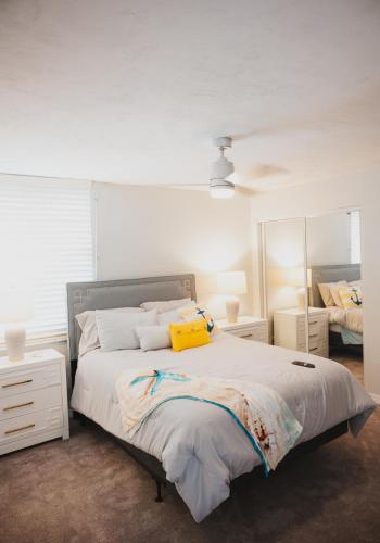 a bedroom with a bed with a yellow pillow on it at Sea Turtle Bungalow in Ormond Beach