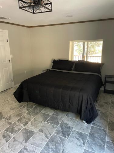 una camera da letto con un letto con un piumone nero di Spotted fawn ranch a Gatesville
