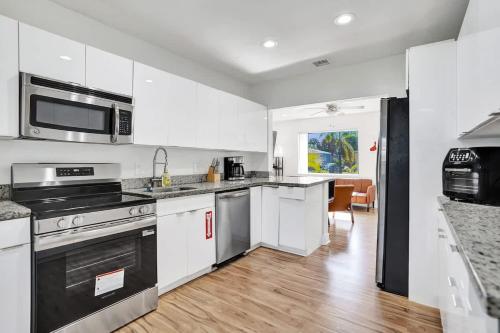 a kitchen with stainless steel appliances and white cabinets at Villa Riviera Beach -4Bdr Relaxing Retreat By Viac in Riviera Beach
