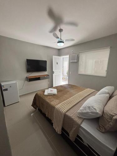 a bedroom with a bed and a ceiling fan at Cantinho da Ilha Suites in Abraão