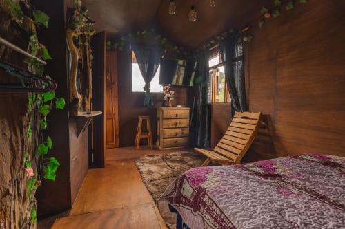 een slaapkamer met een bed, een stoel en een raam bij Trini Treehouse By GEstores in Huasca de Ocampo