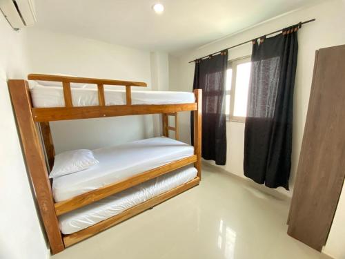 two bunk beds in a room with a window at Apartamento la Isla 2-Coveñas in Coveñas