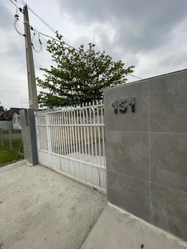 uma cerca branca ao lado de um portão branco em Mini Casa 5 em Itajaí