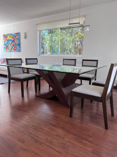 Penthouses Rocas de Santo Domingo Barrio Golf في سانتو دومينغو: غرفة طعام مع طاولة وكراسي زجاجية