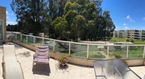 Penthouses Rocas de Santo Domingo Barrio Golf في سانتو دومينغو: شرفة مع كرسي أرجواني وطاولة