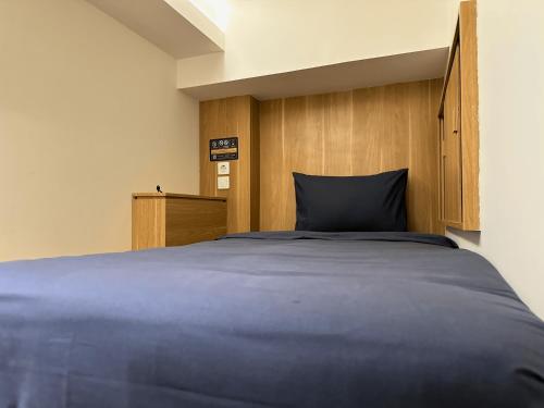 a bedroom with a large bed with a wooden headboard at Althia Capsule Quarters in Badung