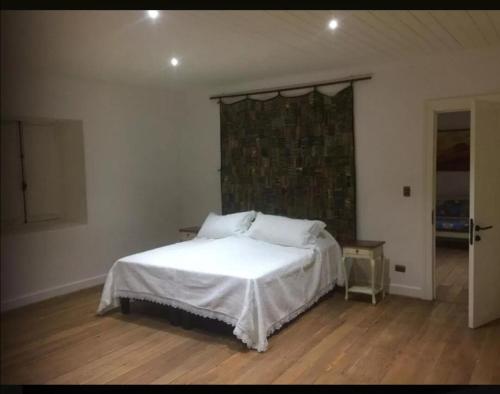 a bedroom with a white bed in a room at Casona Starlight in Melipilla
