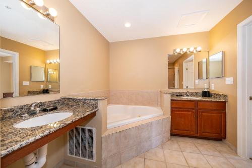 ein Badezimmer mit zwei Waschbecken und einer Badewanne in der Unterkunft Pura Vida a Private Master Bedroom with shared living space in Orlando