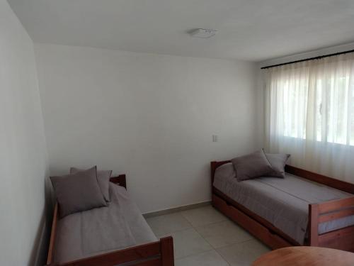 a bedroom with two beds and a window at Selene in Villa Rumipal