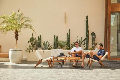 two men sitting on chairs and a table in a lobby at Beston Pattaya - SHA Plus Certified in Pattaya South