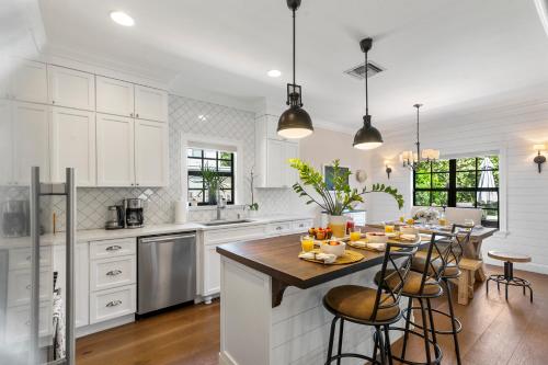 a kitchen with white cabinets and a table with fruits on it at Spanish 4BR Compound w Casita & Private Yard in West Palm Beach