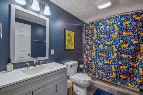 a bathroom with a toilet and a shower curtain at Trailblazer Lodge - Upscale, hot tub, trail, game room, wifi, fire pit, bar, pool table, king bed, view, pet friendly in Berkeley Springs