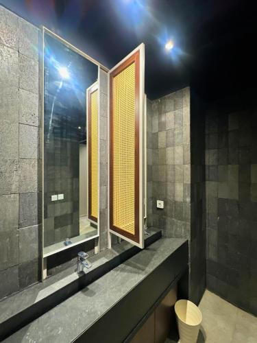 a bathroom with two mirrors and a toilet in it at Althia Private Capsule Quarters in Badung