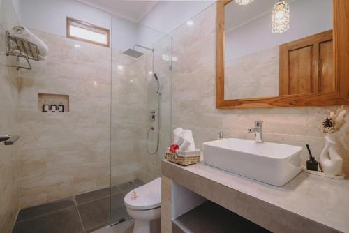 a bathroom with a toilet and a sink and a shower at Villa Royal in Singaraja
