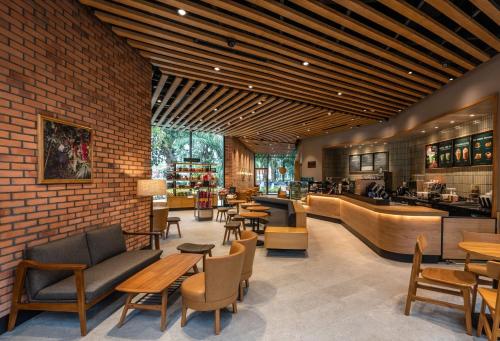 a restaurant with tables and chairs and a brick wall at Happy House Ecopark Westbay A in Cong Luận