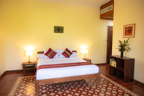 a bedroom with a large bed and two lamps at La maison bleue BTB in Phumĭ Kâmpóng Âmpĭl