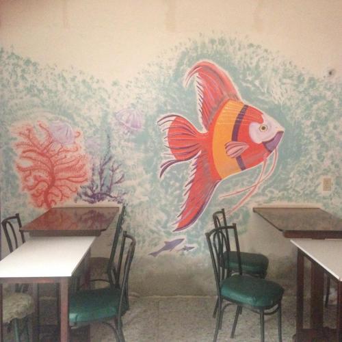 a dining room with a fish mural on the wall at Hostal Camping Beach in Salinas