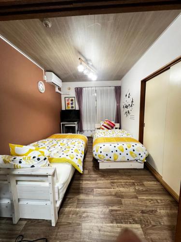 2 letti in una piccola camera da letto con specchio di サイプレス平岸 a Sapporo