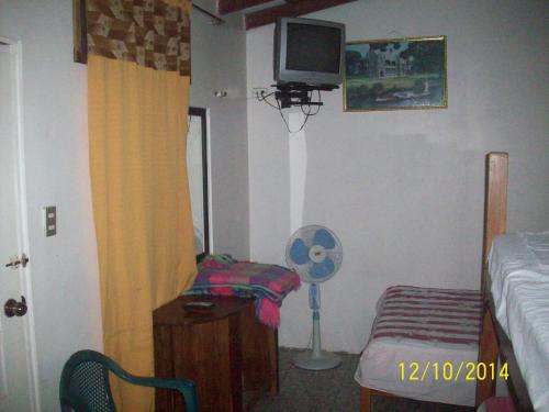a bedroom with a bed and a tv on the wall at Hostal Camping Beach in Salinas