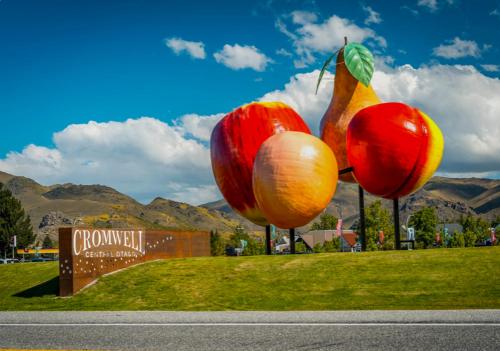 クロムウェルにあるModern Ensuite Room with Light Kitchenette & Private Entrance in Cromwellの畑の柱に立てられた3つの果物の像