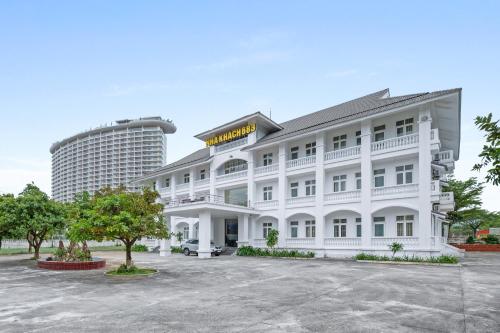 a white hotel with a building in the background at Nhà Khách 683 - Only 10m to Mikazuki - 50m to the Beach in Da Nang