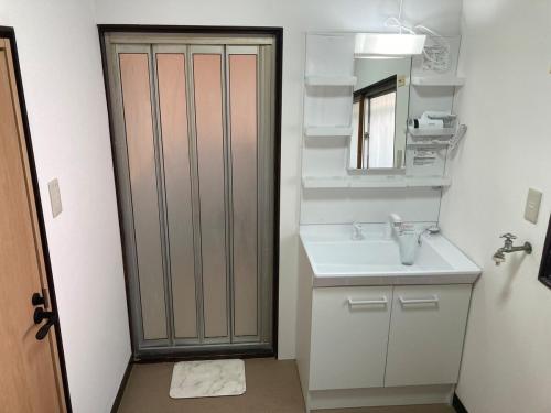 a bathroom with a sink and a mirror at 不入斗-横須賀の大型一棟貸し-最大25人-家族団体向け in Yokosuka