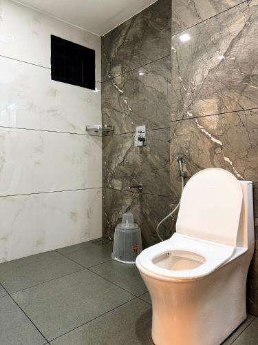 a bathroom with a toilet and a shower at Kenza Retreat in Vagamon