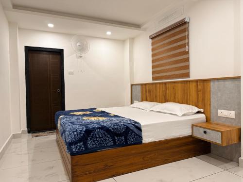 a bedroom with a large bed with a wooden headboard at Kenza Retreat in Vagamon