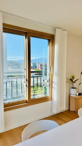 a bedroom with a window with a view of the city at 함덕우리집 in Hamdŏng-ni