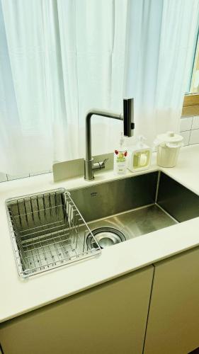 a kitchen sink with a dish rack in it at 함덕우리집 in Hamdŏng-ni