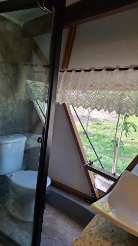 a bathroom with a toilet and a window at Zaca Domos l Ouro Preto - MG in Mariana