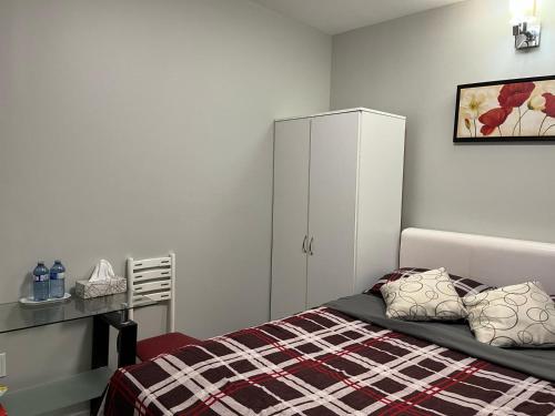 una camera da letto con un letto e un armadio bianco di Surrey Home - King George Blvd & Rapid Transit - Airport 25 Min - Free Parking & Wi-Fi a Surrey