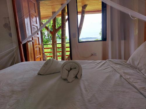 Jungle bar Resto & Cottages في بورت بارتون: قبعة بيضاء تجلس فوق السرير